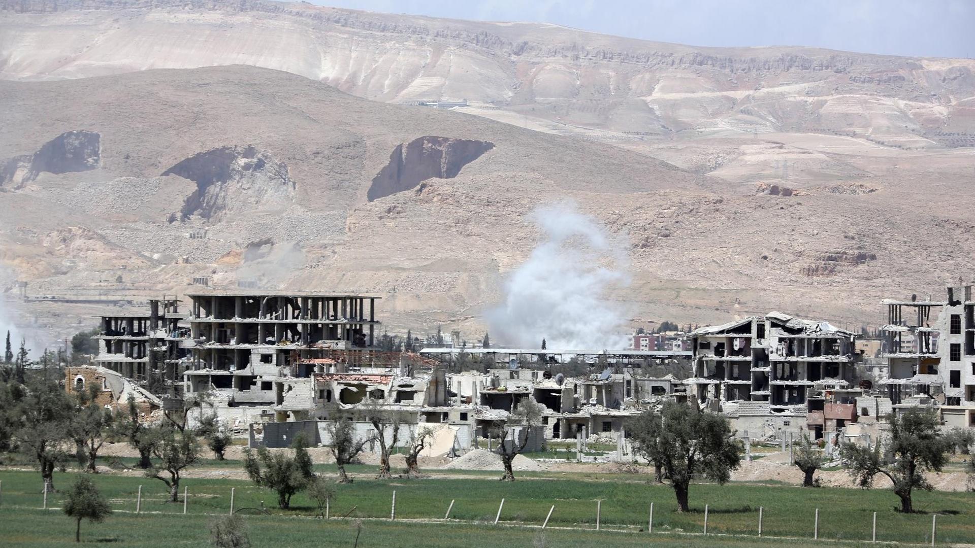 Blick auf die Stadt Douma: zerstörte Betonhäuser vor einer kahlen Landschaft Blick auf die Stadt Douma: zerstörte Betonhäuser vor einer kahlen Landschaft