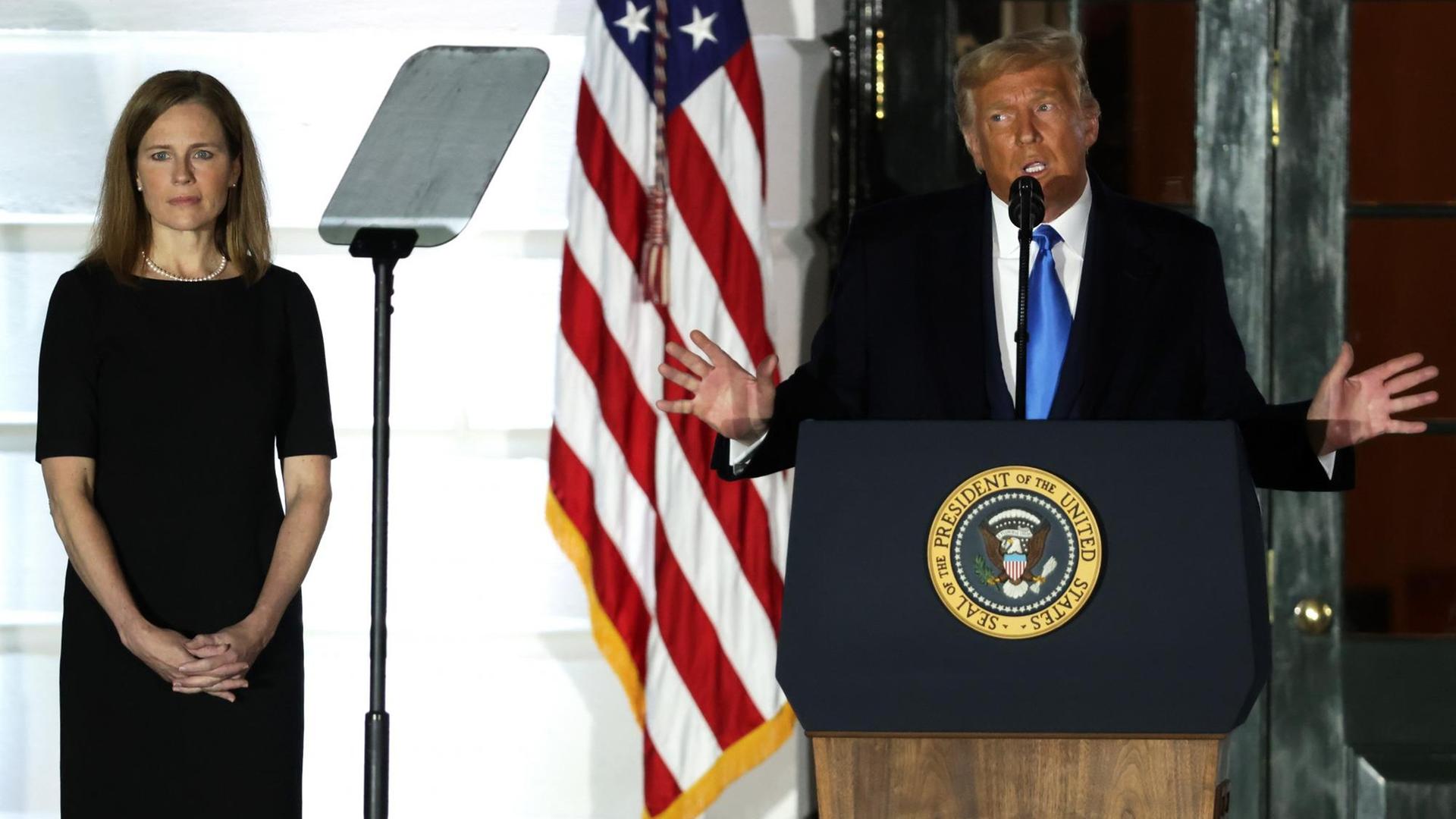 US-Präsident Donald Trump spricht, während Amy Coney Barrett, Associate Justice am Obersten Gerichtshof der USA, während einer feierlichen Vereidigung auf dem South Lawn des Weißen Hauses am 26. Oktober 2020 in Washington, DC, zuhört. US-Präsident Donald Trump spricht, während Amy Coney Barrett, Associate Justice am Obersten Gerichtshof der USA, während einer feierlichen Vereidigung auf dem South Lawn des Weißen Hauses am 26. Oktober 2020 in Washington, DC, zuhört.