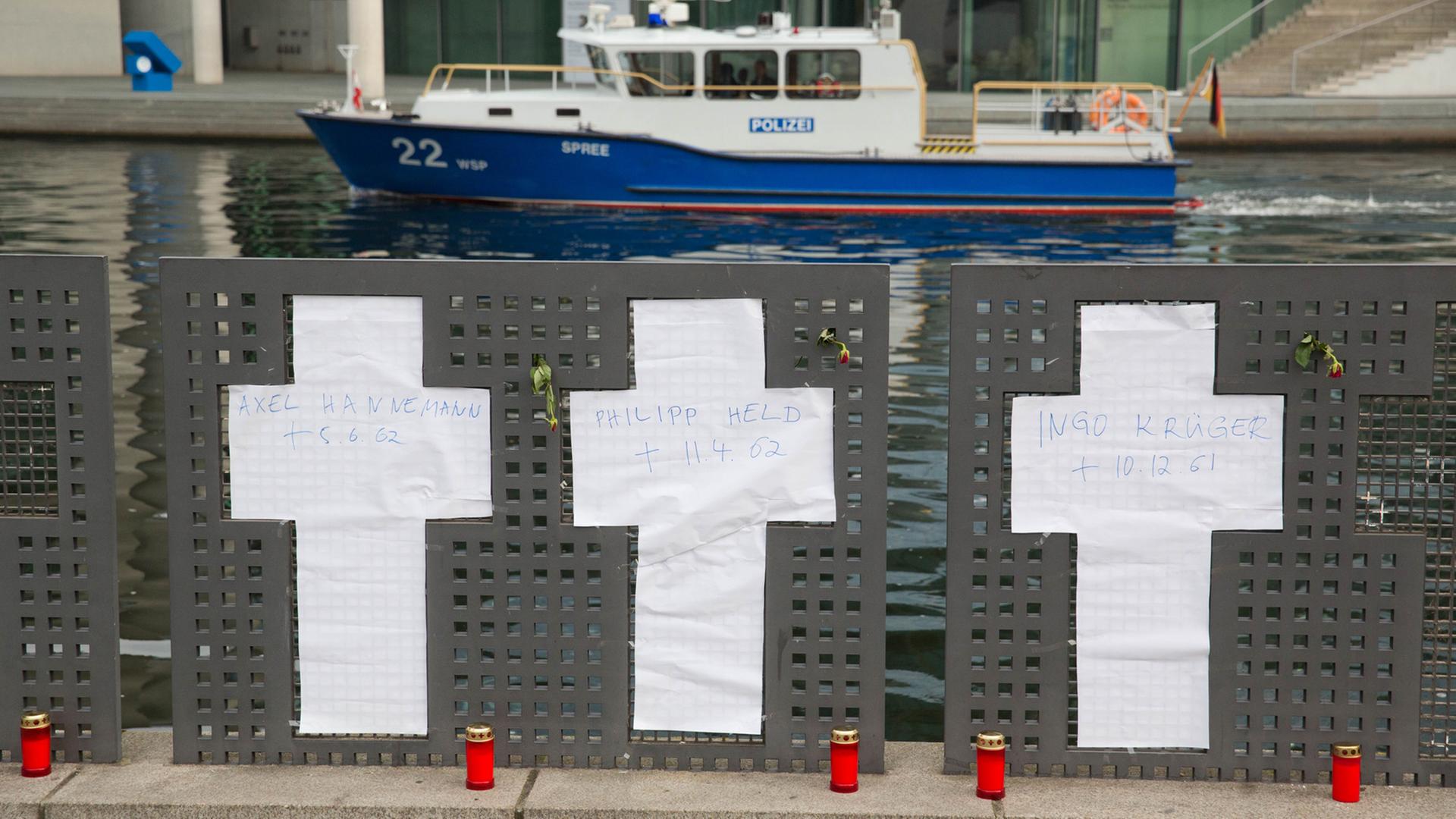 Anstelle der entfernten Gedenkkreuze sind Kreuze aus Papier am Spreeufer in Berlin angebracht. Eine Gruppe von Flüchtlings-Aktivisten hatte die sieben weißen Gedenkkreuze für die Mauertoten am Spreeufer neben dem Reichstag entfernt; Aufnahme vom 5. November 2014