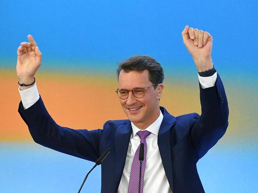 Hendrik Wüst reckt nach der ersten Prognose die Arme in die Luft. 