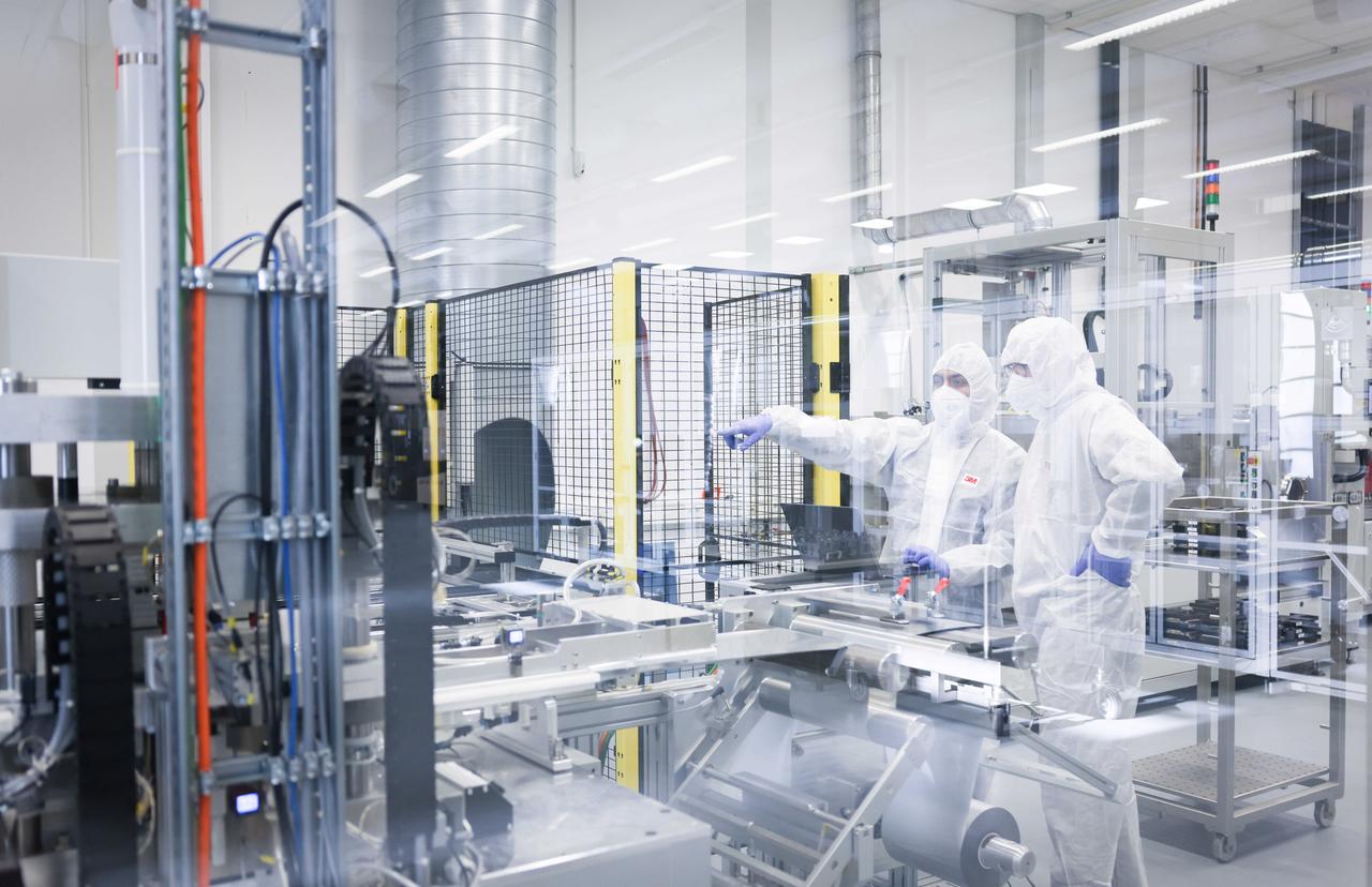 Zwei Prozessingenieur besprechen sich in der Prozessoptimierung und Fertigungskontrolle bei der Herstellung von Lithium-Ionen Zellen in einer Anlage von UniverCell Zwei Prozessingenieur besprechen sich in der Prozessoptimierung und Fertigungskontrolle bei der Herstellung von Lithium-Ionen Zellen in einer Anlage von UniverCell