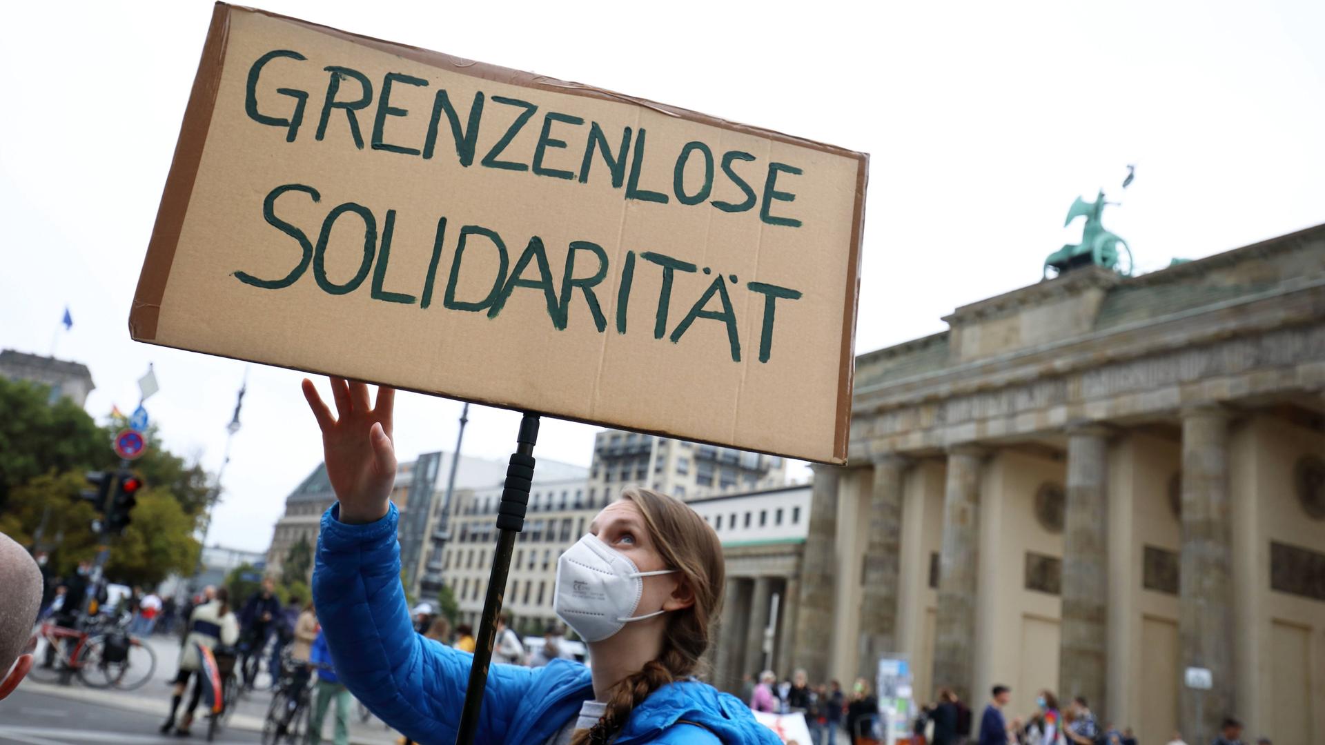 Demonstration in Berlin im September 2021: Eine Frau hält ein Plakat hoch auf dem "Grenzenlose Solidarität" steht. Demonstration in Berlin im September 2021: Eine Frau hält ein Plakat hoch auf dem "Grenzenlose Solidarität" steht.