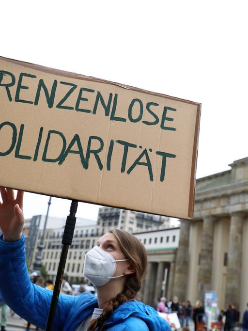 Demonstration in Berlin im September 2021: Eine Frau hält ein Plakat hoch auf dem "Grenzenlose Solidarität" steht. 