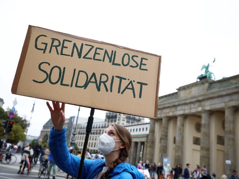 Demonstration in Berlin im September 2021: Eine Frau hält ein Plakat hoch auf dem "Grenzenlose Solidarität" steht. 