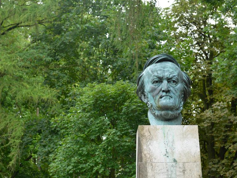 Blick auf die Büste Richard Wagners auf dem Bayreuther Festspielhügel mit viel Grün im Hintergrund.