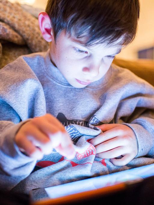Ein Junge spielt an einem Tablet ein Computerspiele