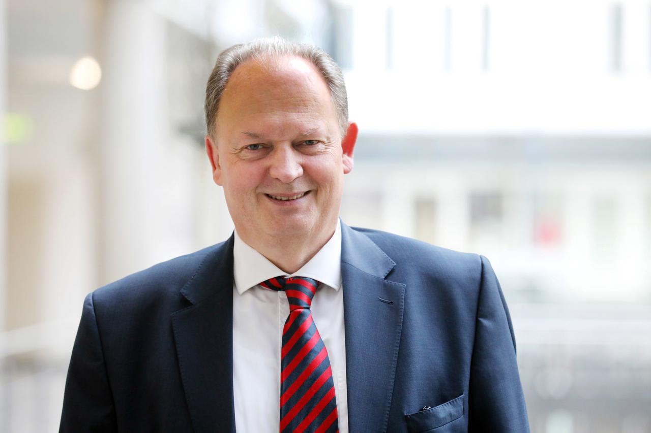 Torsten Oppeland schaut in die Kamera. Er trägt einen blaufarbigen Anzug, weißes Hemd und Krawatte. Der Hintergrund ist unscharf. Torsten Oppeland schaut in die Kamera. Er trägt einen blaufarbigen Anzug, weißes Hemd und Krawatte. Der Hintergrund ist unscharf.