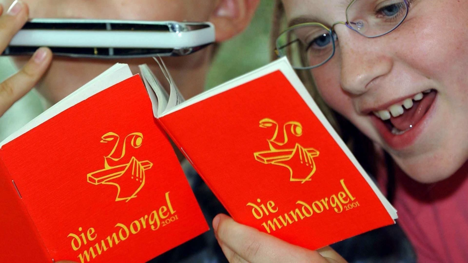 Ein Mädchen singt und ein Junge spielt Mundharmonika zu Liedern aus der "Mundorgel".