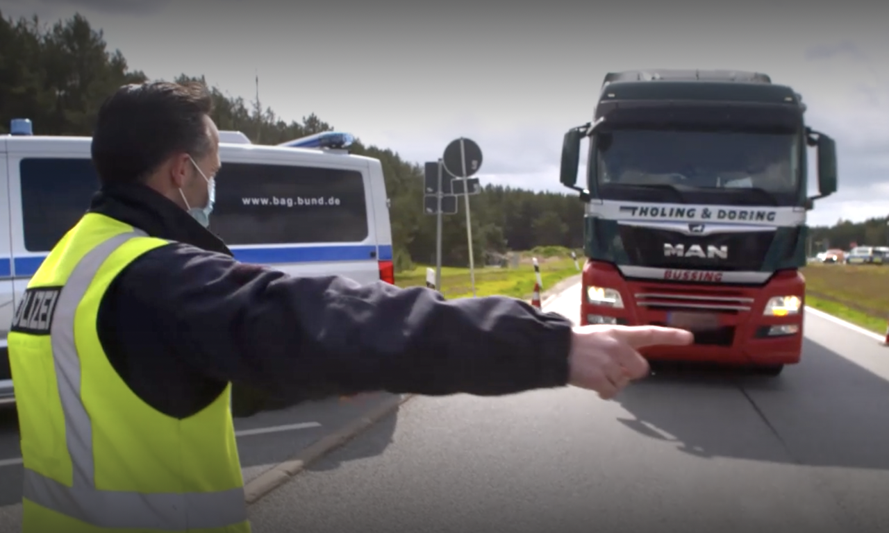 Auf einer Autobahnraststätte hält ein Polizist einen Lkwa an. Auf einer Autobahnraststätte hält ein Polizist einen Lkwa an.