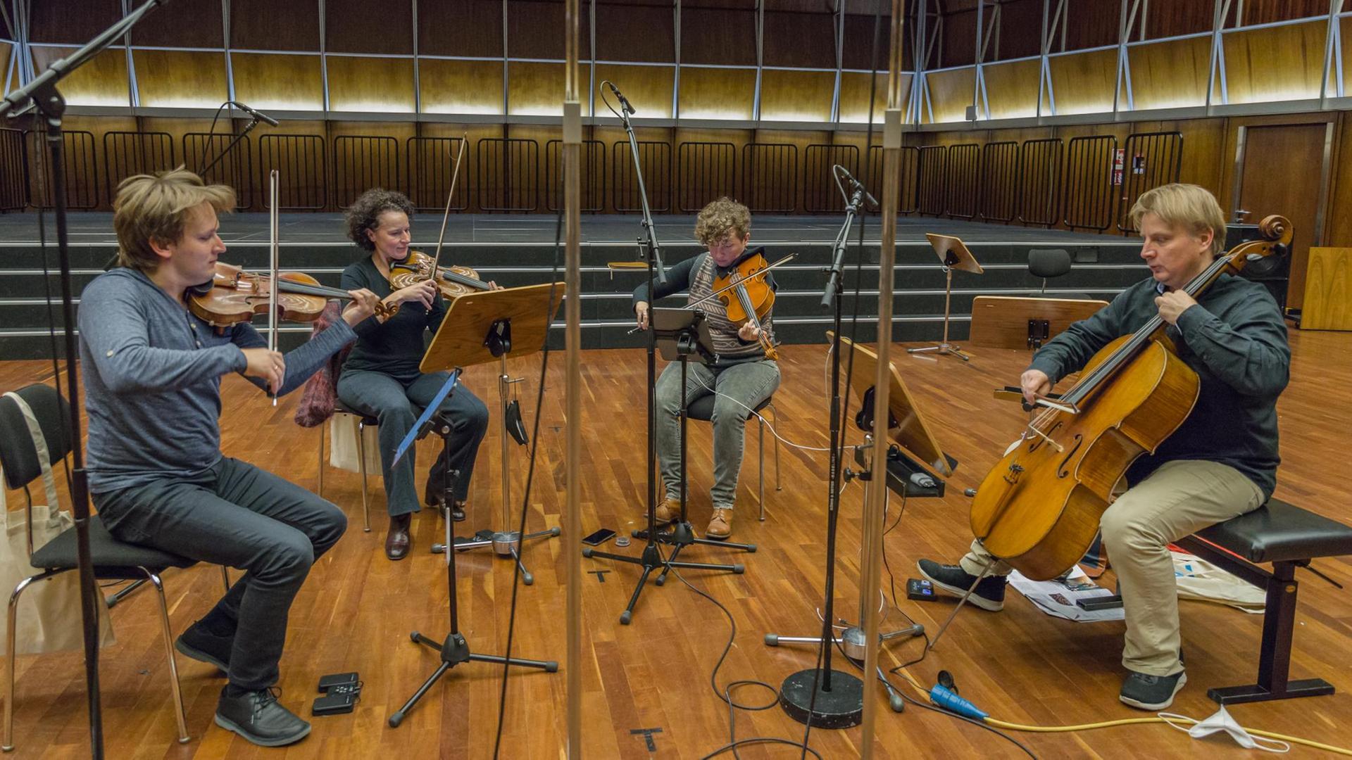 Auf dem Bild sind die vier Musiker des Asasello Quartetts zu sehen, wie sie im Kammermusiksaal proben. Auf dem Bild sind die vier Musiker des Asasello Quartetts zu sehen, wie sie im Kammermusiksaal proben.