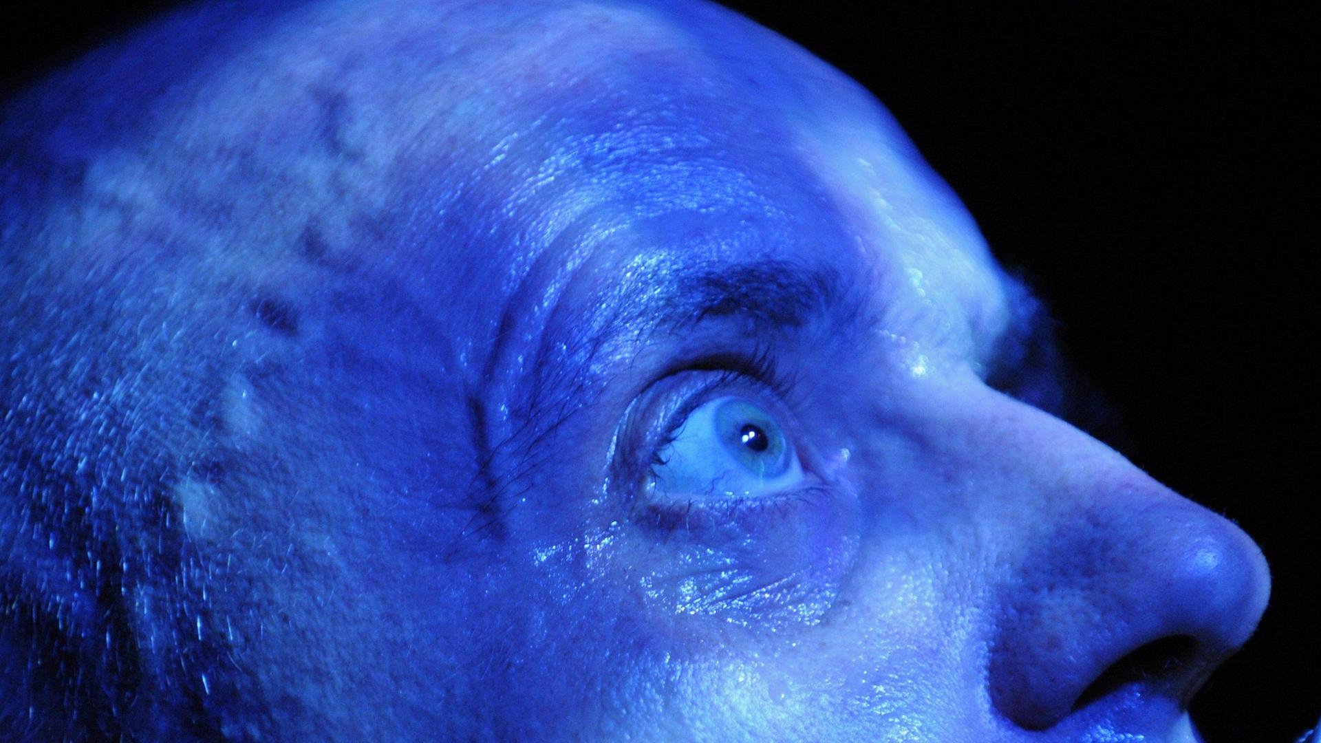 Sänger Kai-Uwe Kohlschmidt (Sandow) beim Konzert in Erfurt 2008. Ein von Bühnenlicht blau beleuchteter kahler Schädel mit weit aufgerissenem Auge singt in ein Mikrofon. Sänger Kai-Uwe Kohlschmidt (Sandow) beim Konzert in Erfurt 2008. Ein von Bühnenlicht blau beleuchteter kahler Schädel mit weit aufgerissenem Auge singt in ein Mikrofon.