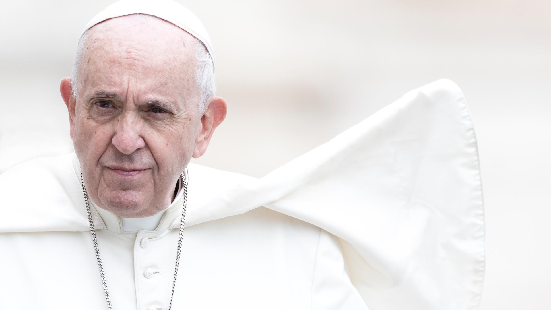 Portrait von Papst Franziskus ganz in weiß vor weißem, verschwommenen Hintergrund.