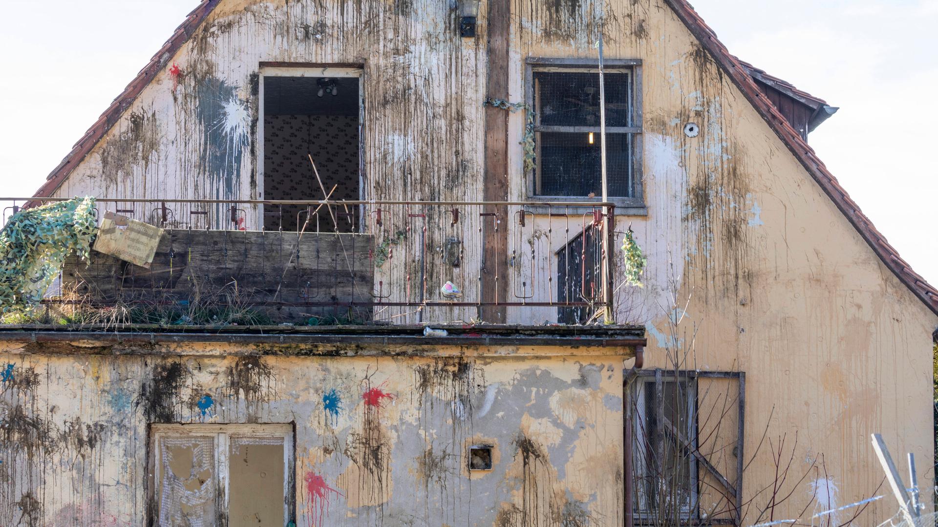 Frontalansicht der Fassade eines Hauses im desolaten Zustan, das mit zahlreichen Farbbeutel beworfen wurde. Frontalansicht der Fassade eines Hauses im desolaten Zustan, das mit zahlreichen Farbbeutel beworfen wurde.
