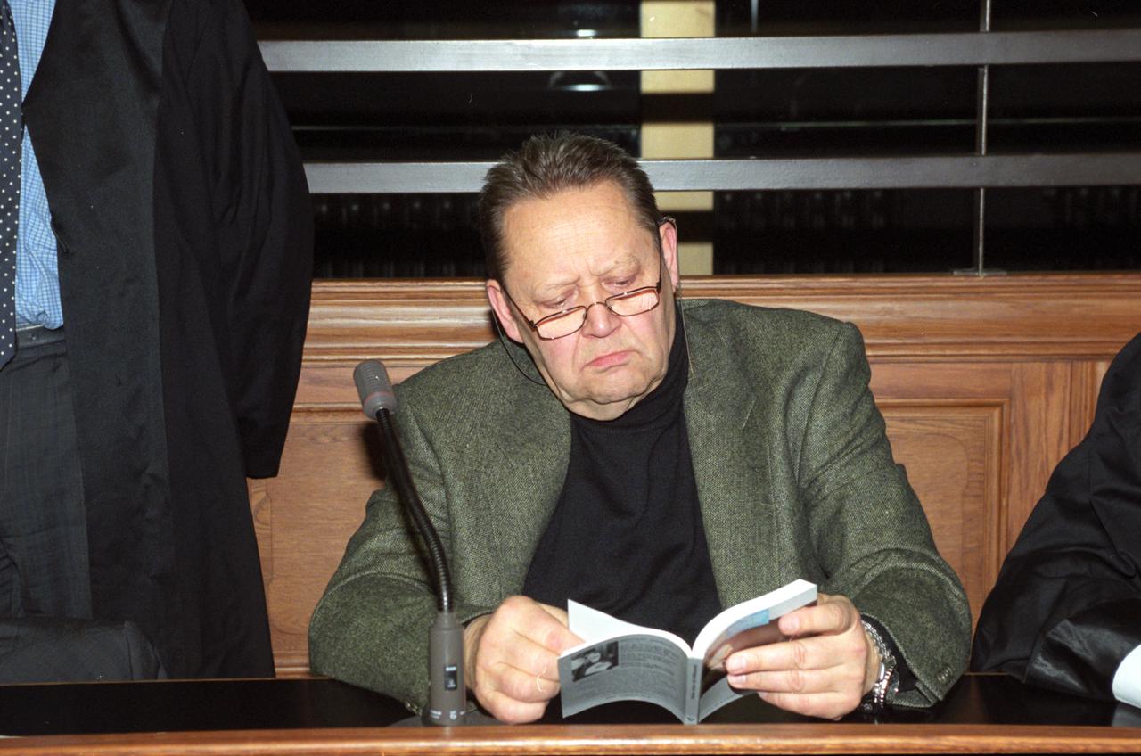 Der ehemalige SED-Parteichef Berlins, Günter Schabowski, liest in einem Buch vor Prozessbeginn im Gerichtssaal in Berlin-Moabit