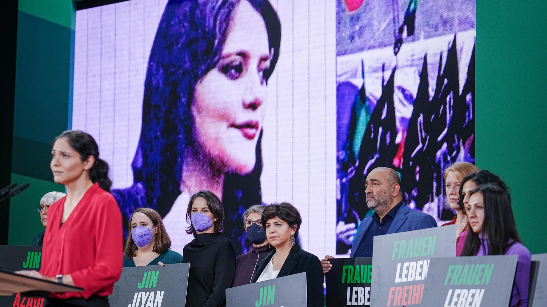 Annalena Baerbock (3.vl, Bündnis 90/Die Grünen), AuÃenministerin, und die Schauspielerin Pegah Ferydoni (l) stehen beim Bundesparteitag von Bündnis 90/Die Grünen während einer Kundgebung für die Frauen im Iran gemeinsam auf der Bühne. 