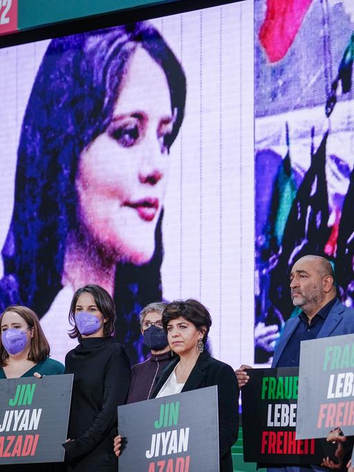 Annalena Baerbock (3.vl, Bündnis 90/Die Grünen), AuÃenministerin, und die Schauspielerin Pegah Ferydoni (l) stehen beim Bundesparteitag von Bündnis 90/Die Grünen während einer Kundgebung für die Frauen im Iran gemeinsam auf der Bühne. 