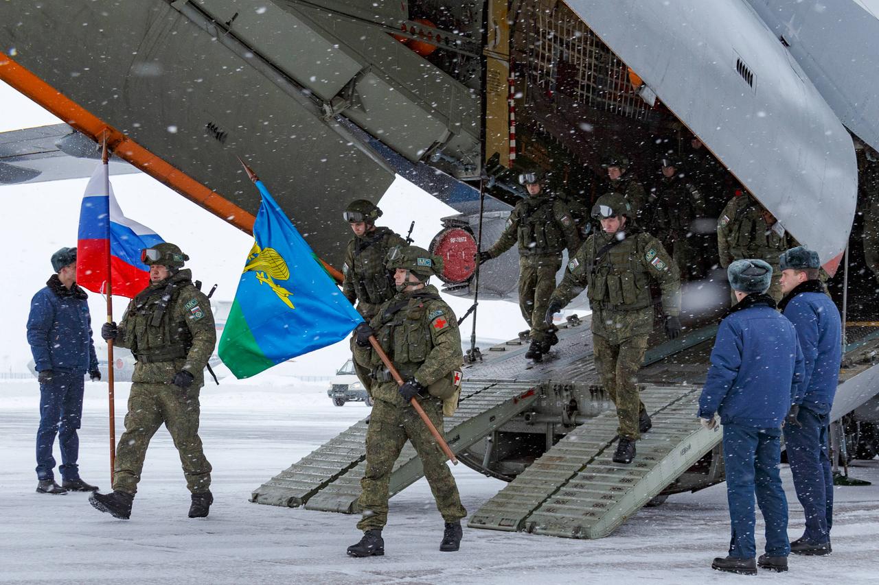 Soldaten laufen aus dem Frachtraum eines Flugzeugs, sie tragen eine Fahne von Russland.