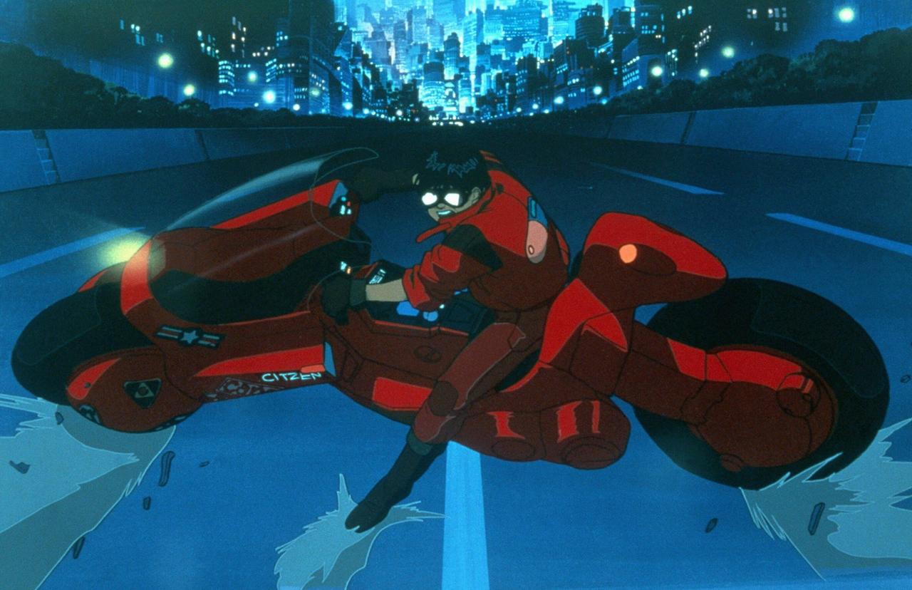 Eine Szene aus dem Anime-Film "Akira": Eine Figur sitzt auf einen Motorrad, dieses ist quer auf der Straße gestellt. Im Hintergrund ist die Skyline von Neo-Tokyo.