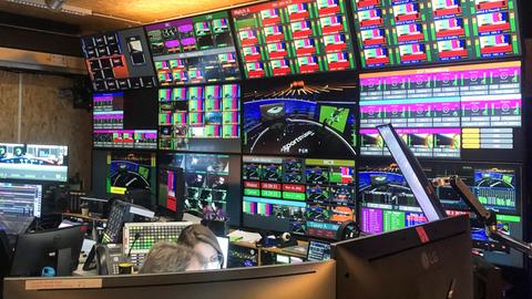 Blick in den technischen Kontrollraum im WM-Sendezentrum von ARD und ZDF. das Bild zeigt eine Wand mit Monitoren.