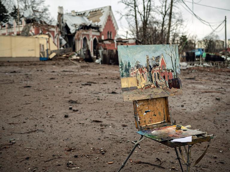 Ukraine-Krieg 2022. Die Großstadt Tschernihiw, ca. 150 km nordöstlich von Kiew, wurde von Ende Februar bis Ende März von russischen Truppen belagert und mehrfach von der Luftwaffe bombardiert. Der ortsansässige Künstler Viktor Onyshchenko malt die bei den russischen Luftangriffen vom 11. März zerstörte Bibliothek. Tschernihiw, Oblast Tschernihiw, Ukraine, 08.04.2022