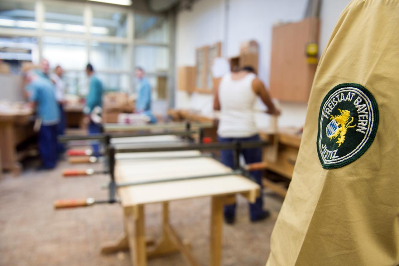 Ein Justizbeamte beaufsichtigt die Arbeit von Häftlingen. Ein Justizbeamte beaufsichtigt die Arbeit von Häftlingen.