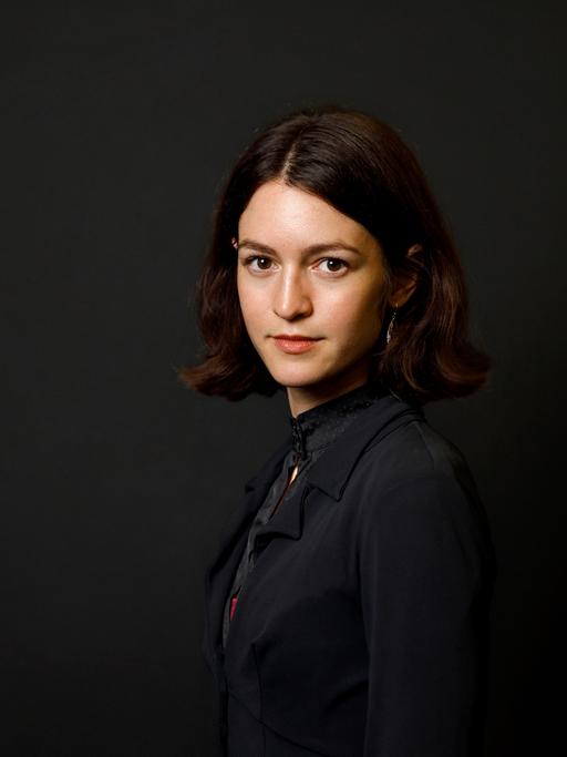 Julia Ebner posiert vor einem schwarzen Hintergrund für ein Porträt.