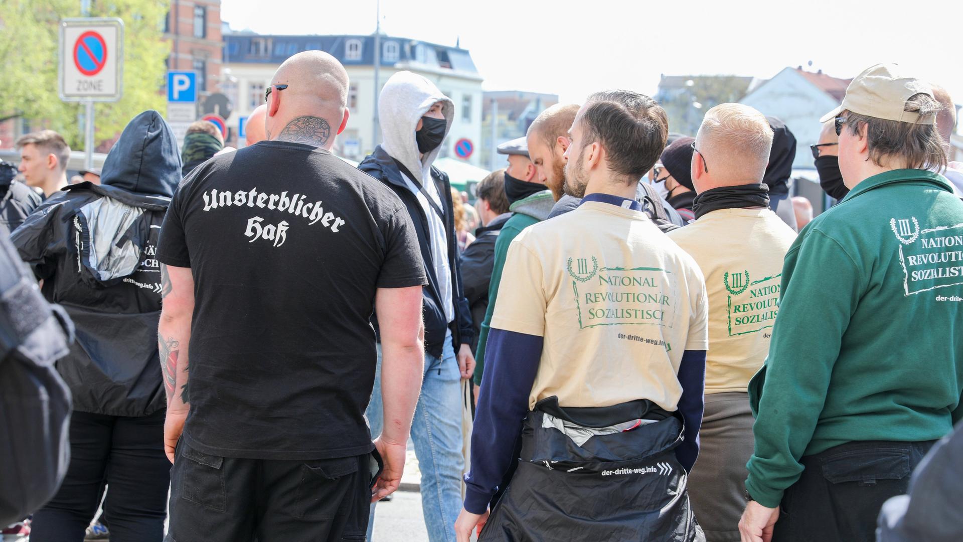 Von hinten abgebildete Teilnehmer der Demo der rechtsextremen Splitterpartei "III. Weg". Auf einem T-Shirt steht auf dem Rücken eines Glatzkopfes in Frakturschrift "Unsterblicher Hass". Von hinten abgebildete Teilnehmer der Demo der rechtsextremen Splitterpartei "III. Weg". Auf einem T-Shirt steht auf dem Rücken eines Glatzkopfes in Frakturschrift "Unsterblicher Hass".