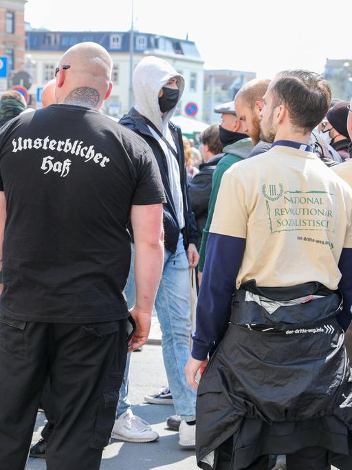 Von hinten abgebildete Teilnehmer der Demo der rechtsextremen Splitterpartei "III. Weg". Auf einem T-Shirt steht auf dem Rücken eines Glatzkopfes in Frakturschrift "Unsterblicher Hass".