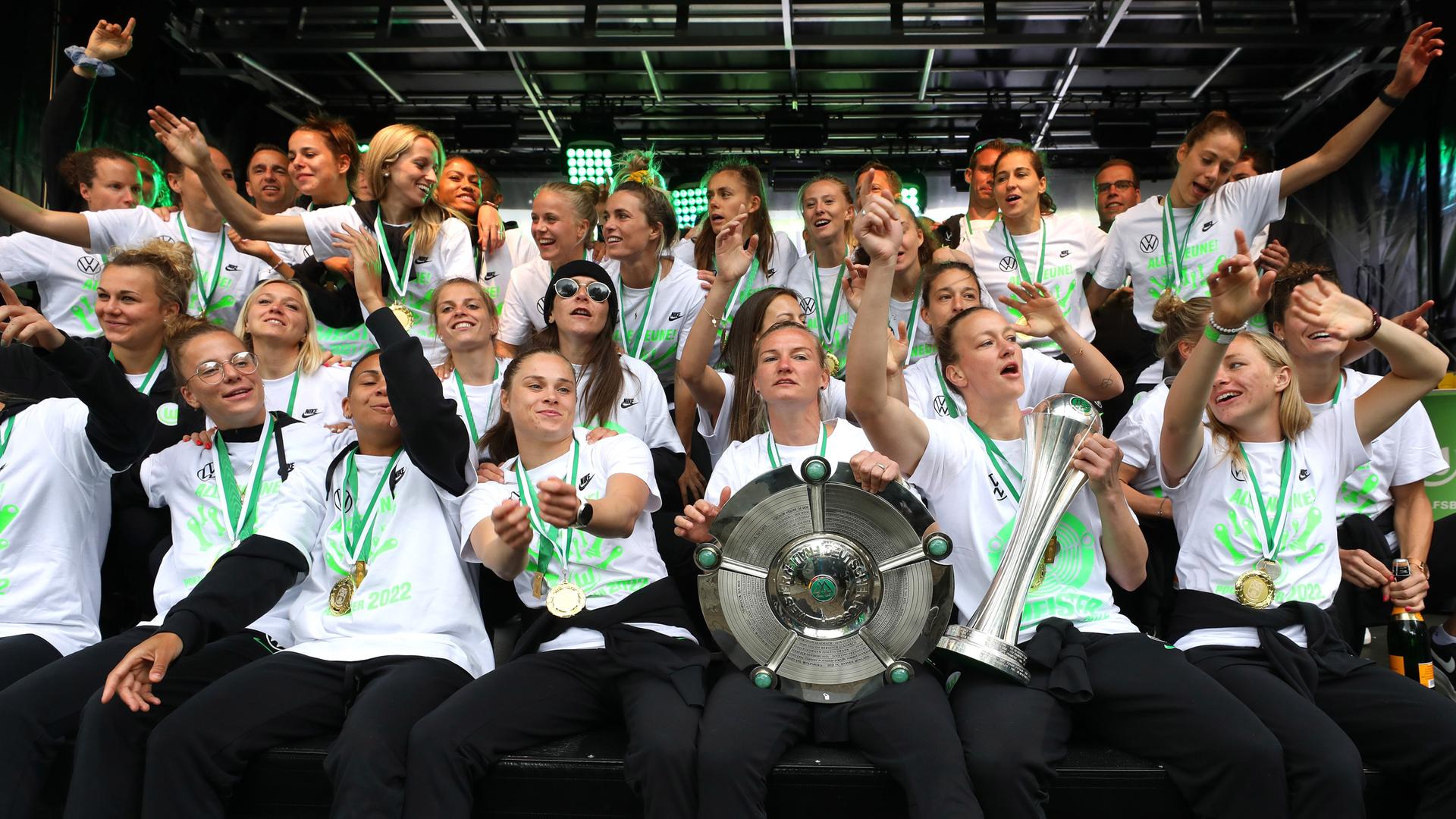 Die Fußballerinnen von Wolfsburg feiern ihren Sieg im DFB-Pokal. Sie stehen alle zusammen im Rathaus von Wolfsburg. Die Fußballerinnen von Wolfsburg feiern ihren Sieg im DFB-Pokal. Sie stehen alle zusammen im Rathaus von Wolfsburg.