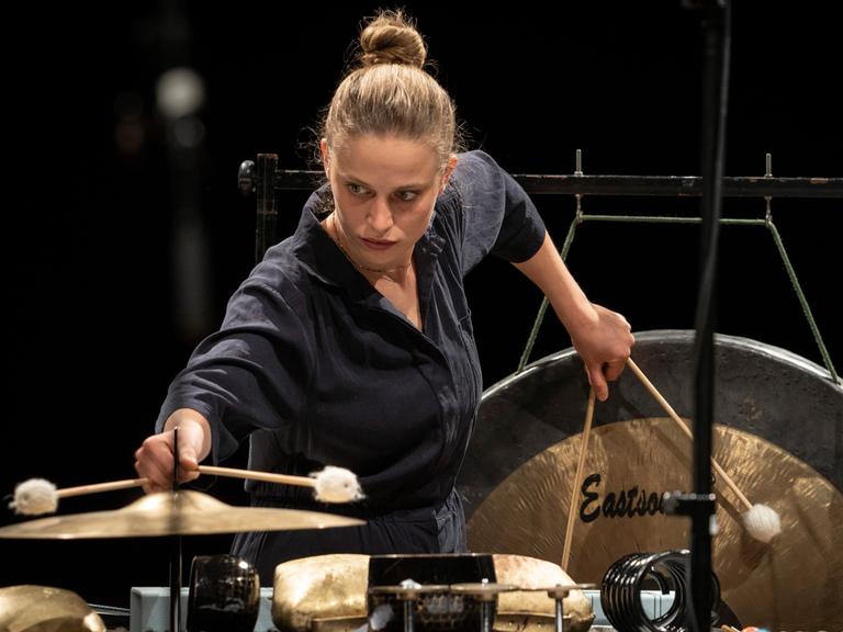 Eine junge Frau am Schlagzeug spielt mit zwei Schlägeln in jeder Hand