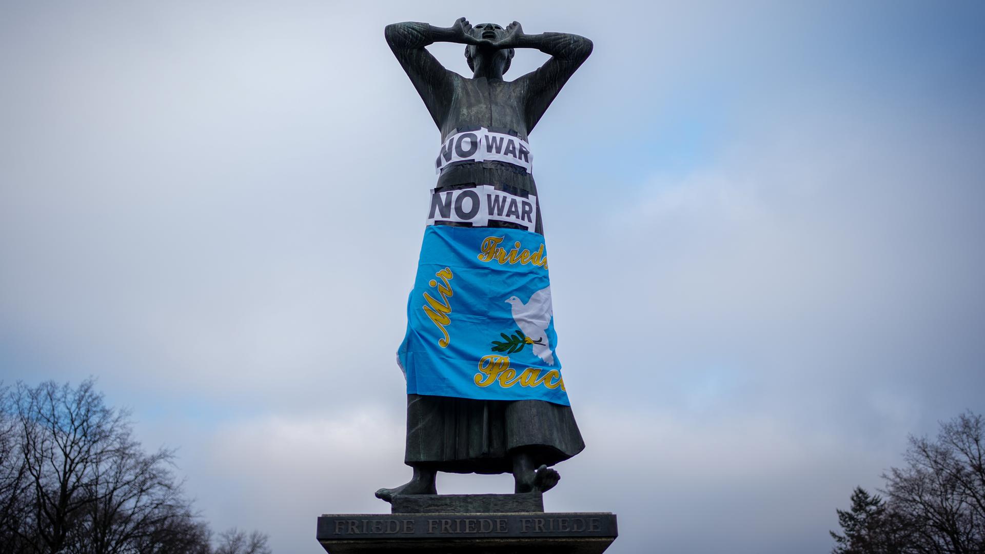 Plakate mit der Aufschrift "No war" sind an der Statue "Der Rufer" als Protest gegen den Krieg in der Ukraine auf der Straße des 17. Juni zu sehen. Plakate mit der Aufschrift "No war" sind an der Statue "Der Rufer" als Protest gegen den Krieg in der Ukraine auf der Straße des 17. Juni zu sehen.