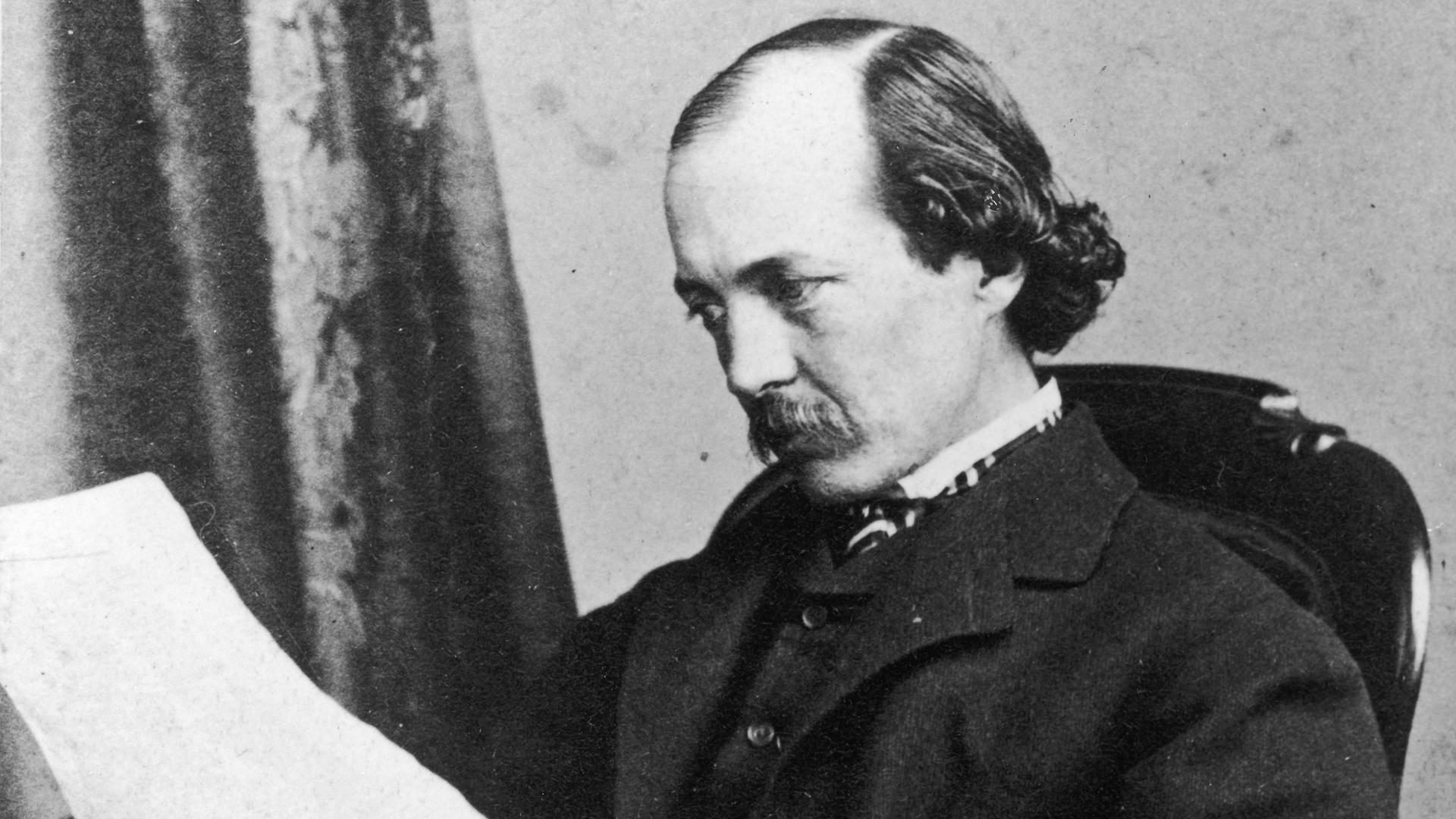 Porträt von Fredrick Law Olmsted, in einem Sessel sitzend mit Zeitung. Porträt von Fredrick Law Olmsted, in einem Sessel sitzend mit Zeitung.