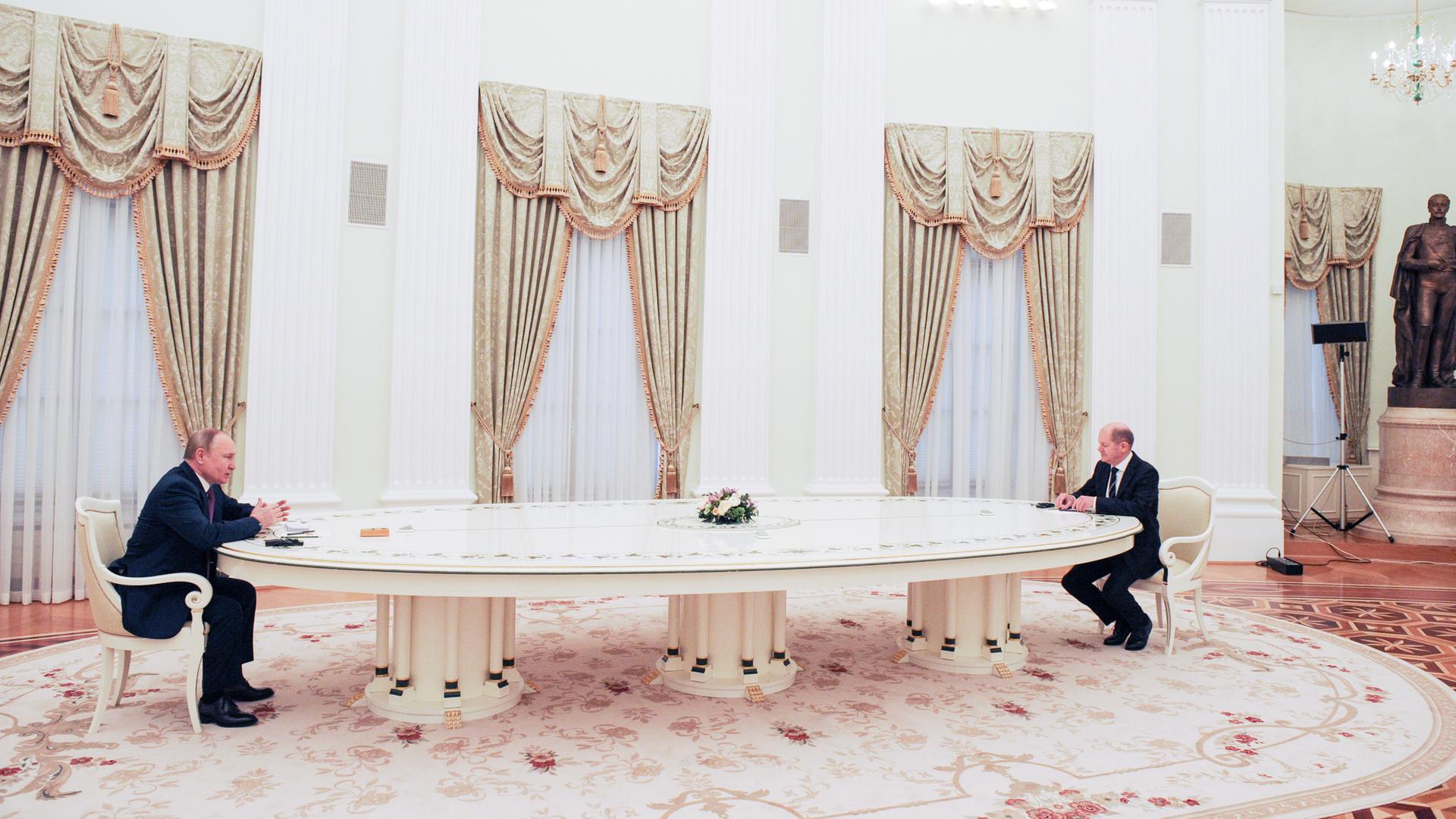 Der russische Präsident Wladimir Putin, sein Tisch und Bundeskanzler Olaf Scholz in Moskau