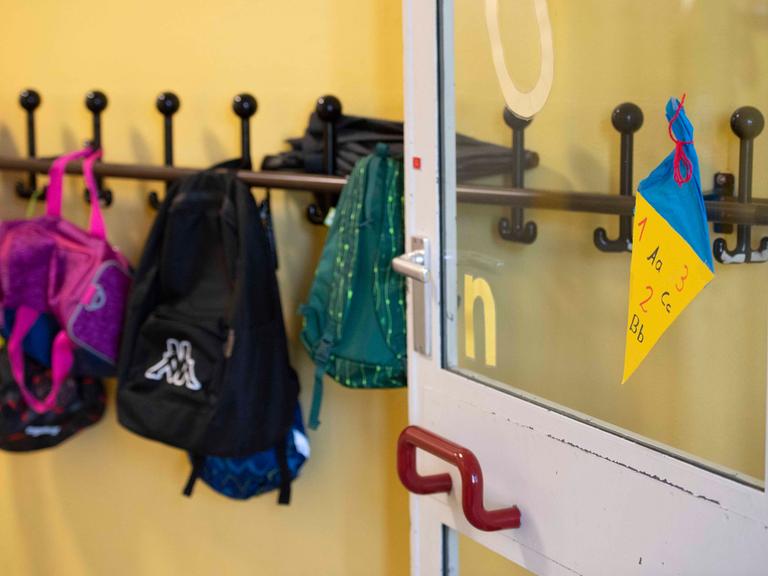 Garderobe mit aufgehängter Kinderkleidung und Taschen in einer Schule.