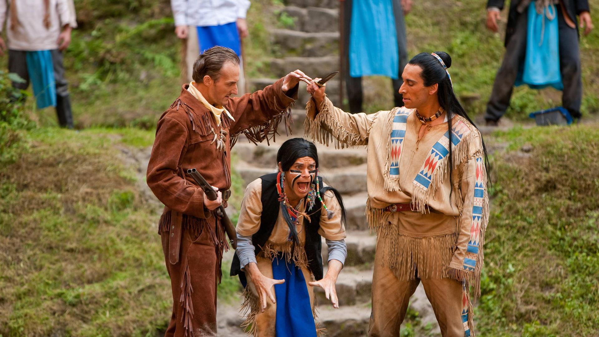 Szene aus der Karl-May-Festspiele Aufführung "Der Ölprinz". Links ein Indianer, rechts ein weisser Mann mit Gewehr.