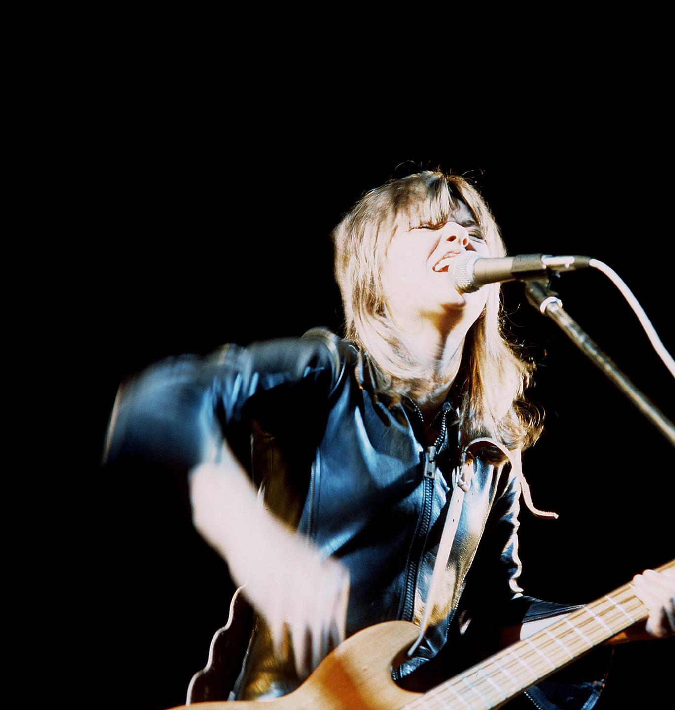 Sängerin Suzi Quatro singt leidenschaftlich auf der Bühne. Sängerin Suzi Quatro singt leidenschaftlich auf der Bühne.