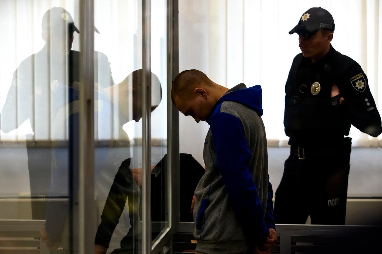 Der 21-jährige Russische Soldat, der verurteilt wurde, steht während des Prozess' mit gesenktem Kopf in einem Glaskasten. Der 21-jährige Russische Soldat, der verurteilt wurde, steht während des Prozess' mit gesenktem Kopf in einem Glaskasten.