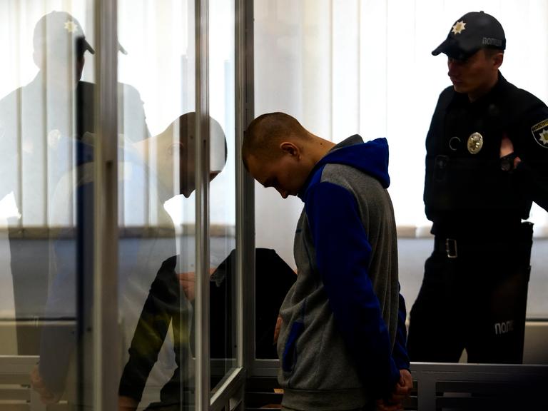 Der 21-jährige Russische Soldat, der verurteilt wurde, steht während des Prozess' mit gesenktem Kopf in einem Glaskasten.