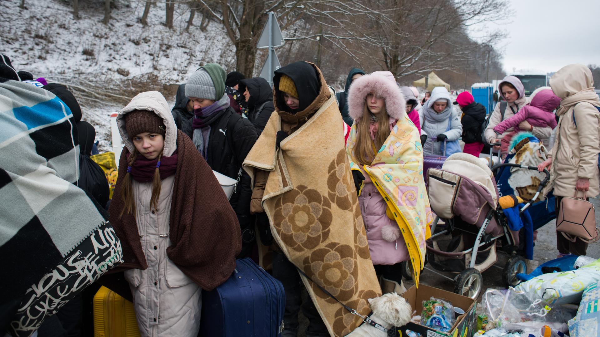 Ukrainische Flüchtlinge warten mit Decken an der polnischen Grenze auf ihre Einreise. 