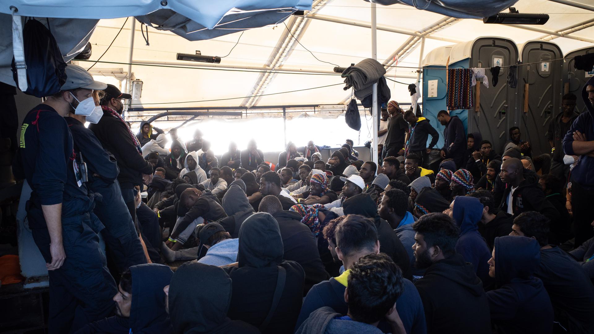 Die von der Hilfsorganisation SOS Humanity herausgegebene Aufnahme zeigt aus dem Mittelmeer gerettete Flüchtlinge, die an Deck des deutschen Seenotrettungsschiffes "Humanity 1" sitzen.