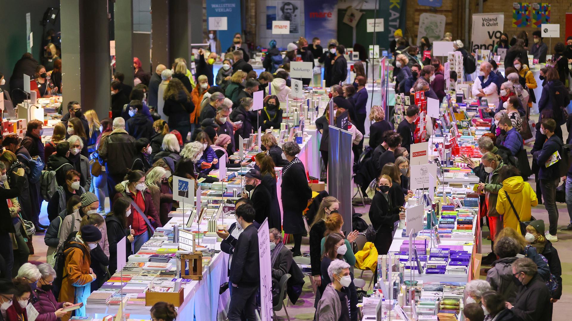 Publikum bei der Pop-Up-Buchmesse in Leipzig an Tischen mit Büchern.