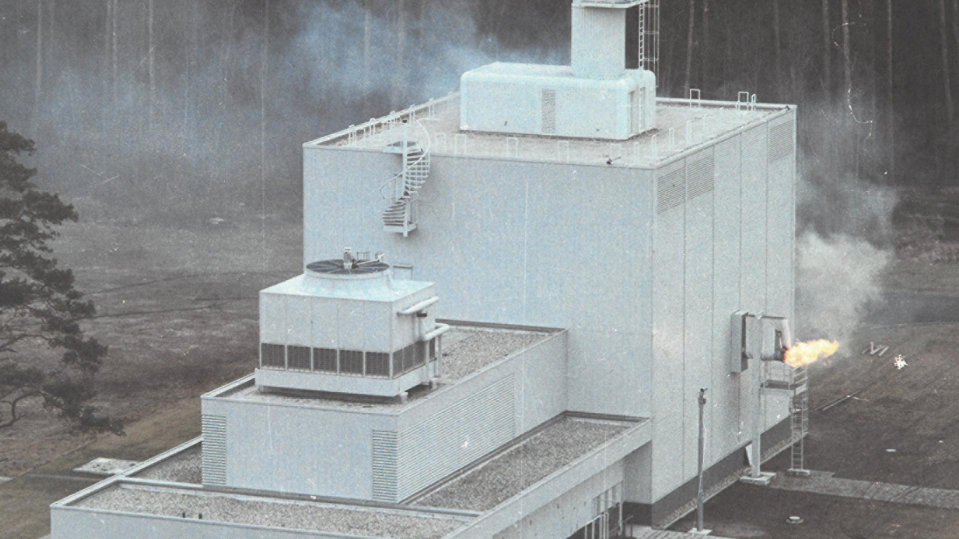 Abbildung eines Kernforschungszentrums, aus dessen Seite Feuer austritt.