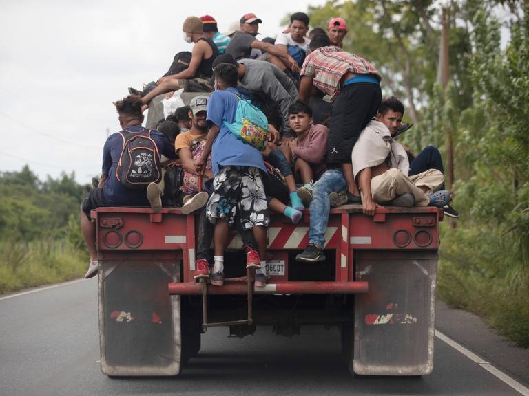 Flüchtlinge auf der Ladefläche eines Frachtwagens.