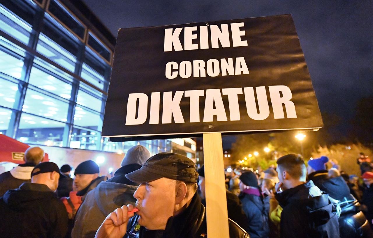 "Keine Corona Diktatur" steht auf dem Plakat, das ein Mann bei einer Demonstration vor dem Thüringer Landtag in den Händen hält. "Keine Corona Diktatur" steht auf dem Plakat, das ein Mann bei einer Demonstration vor dem Thüringer Landtag in den Händen hält.