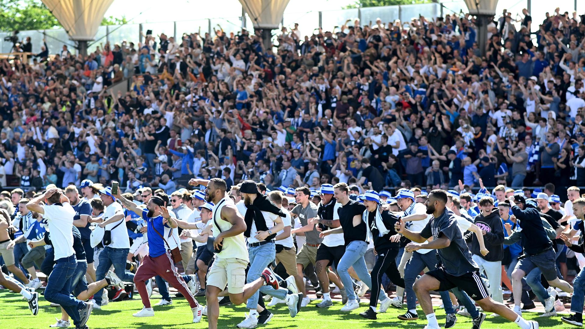 Olddenburger Fans stürmen jubelnd von der Tribüne auf den Platz. Olddenburger Fans stürmen jubelnd von der Tribüne auf den Platz.