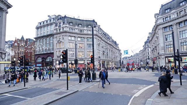 Menschen gehen in London über eine Kreuzung auf dem Oxford Circus.