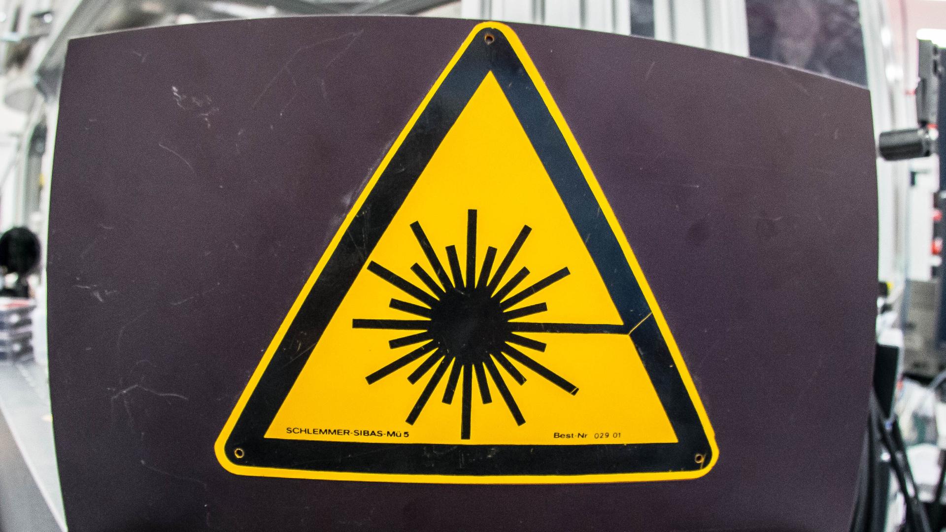 Ein Schild zeigt symbolisch die Kernfusion mithilfe von Laserstrahlen