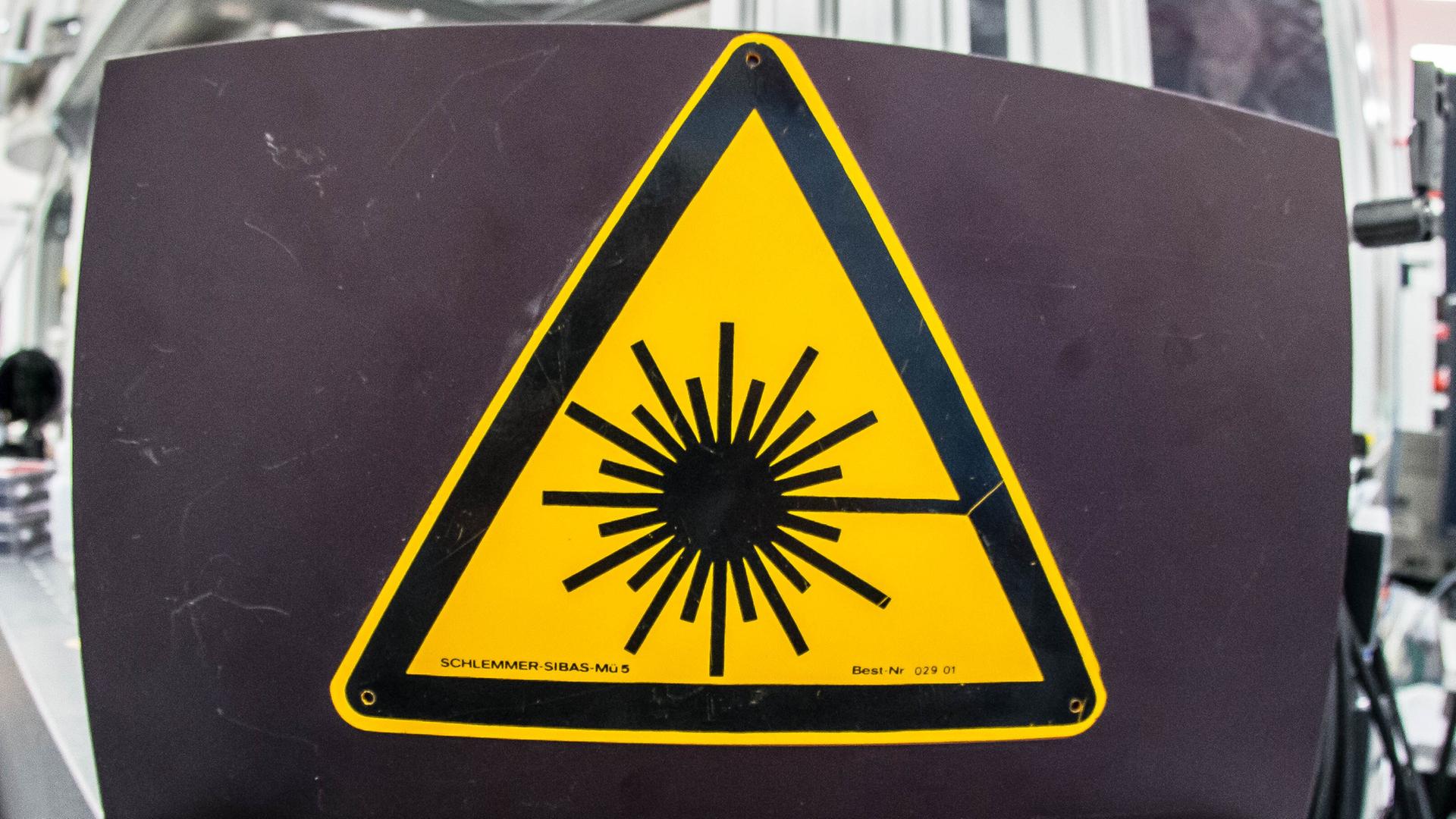 Ein Schild zeigt symbolisch die Kernfusion mithilfe von Laserstrahlen Ein Schild zeigt symbolisch die Kernfusion mithilfe von Laserstrahlen