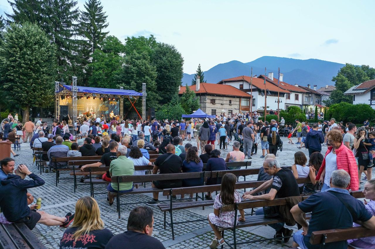 Fest in Bansko. Menschen sitzen auf einem Platz auf Bänken und schauen auf eine Bühne. Fest in Bansko. Menschen sitzen auf einem Platz auf Bänken und schauen auf eine Bühne.