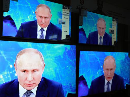 Das Gesicht Vladimir Putins vierfach auf einem Bildschirm.
